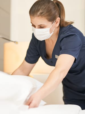Staff member adjusting bedding in a resident room