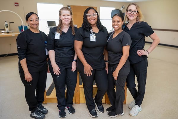 Staff members smiling together in a common area