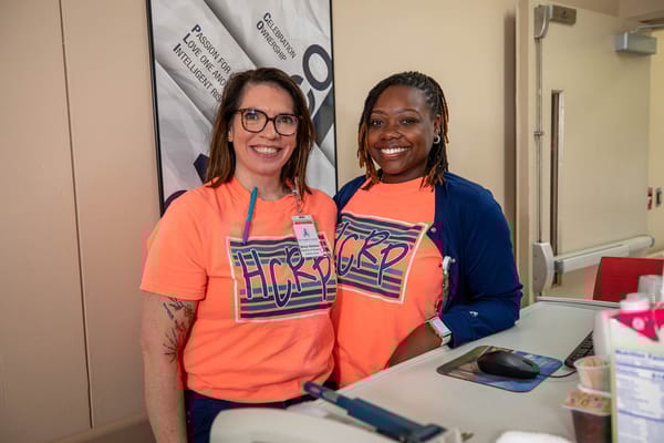 Two staff members smiling at a reception desk