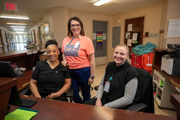 Staff members at the reception desk in a facility hallway