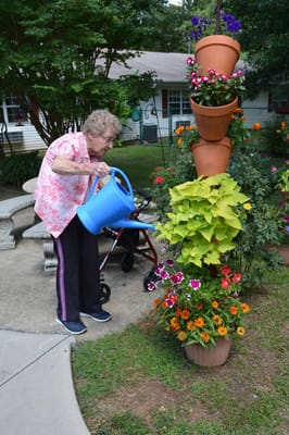 Resident watering flowers in an outdoor garden