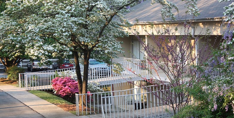 Exterior view of the facility with blooming flowers and trees