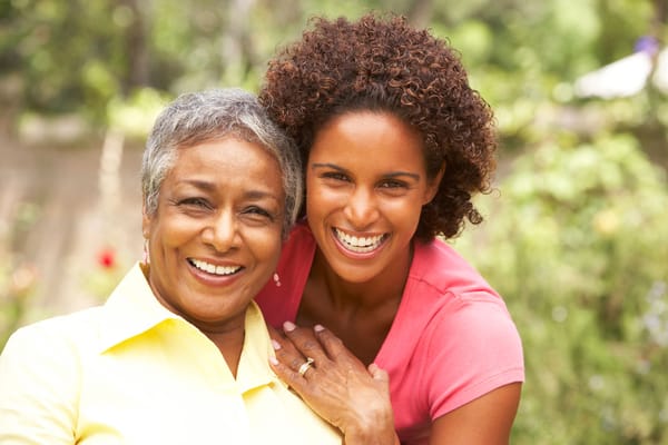 Two women smiling in a garden setting