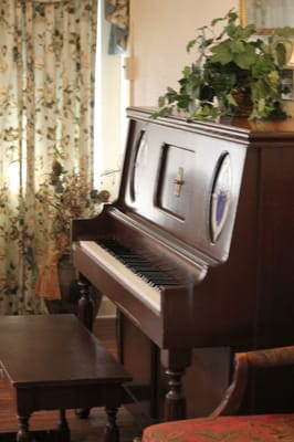 A wooden piano in a cozy interior setting