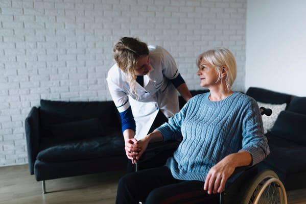 Staff assisting a resident in a cozy interior space
