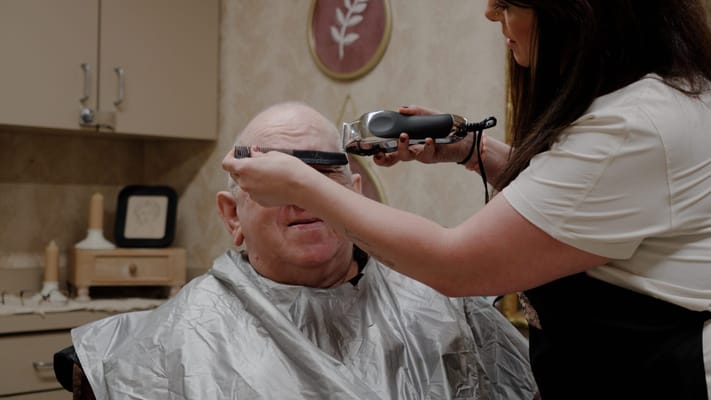 A resident receiving a haircut in a salon