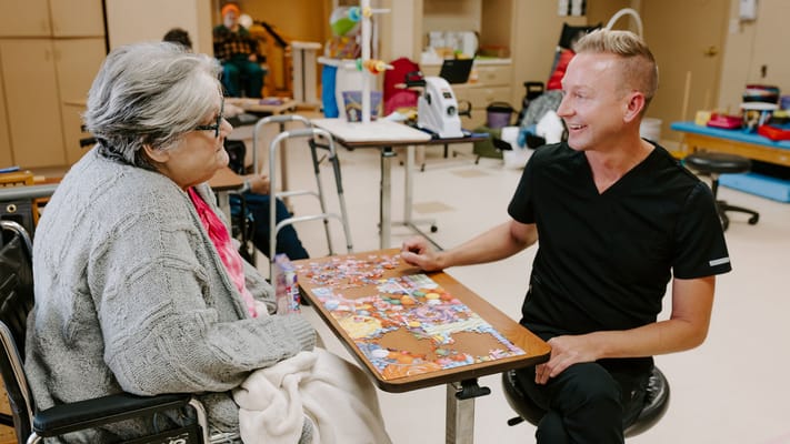 Staff engaging with a resident during a puzzle activity