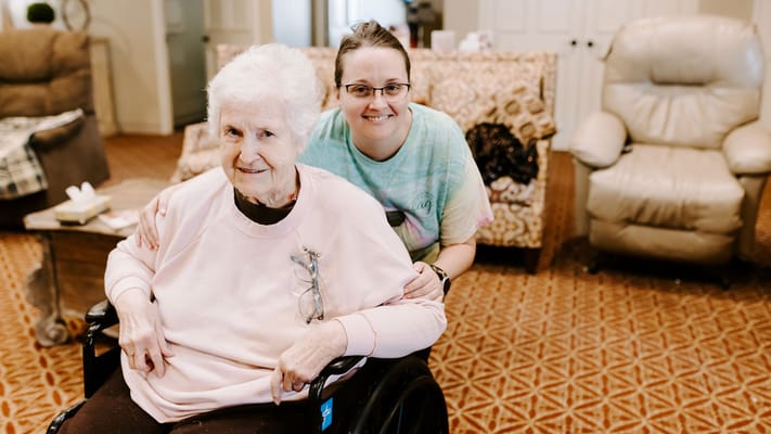 Staff member helping a resident in the lounge.