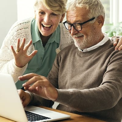 Residents engaging with a laptop and smiling