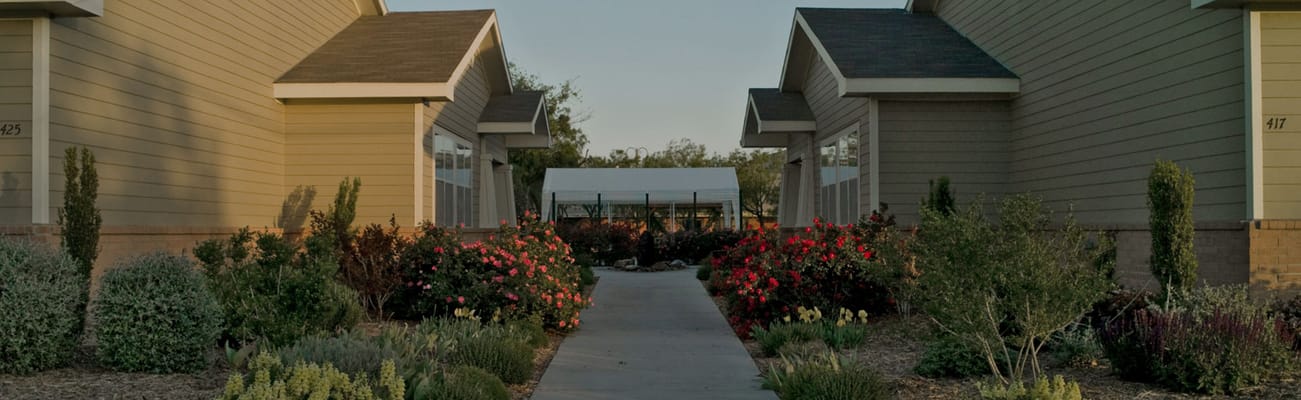 Pathway lined with flowers leading to cottages
