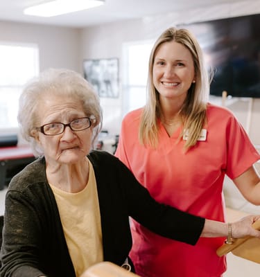 Care staff assisting a resident in a bright activity room