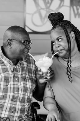 Couple sharing a dessert with two straws