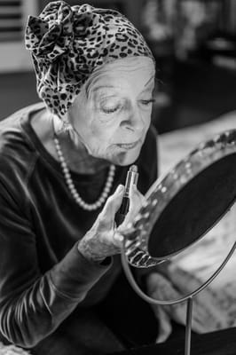 Resident applying makeup in a warm interior