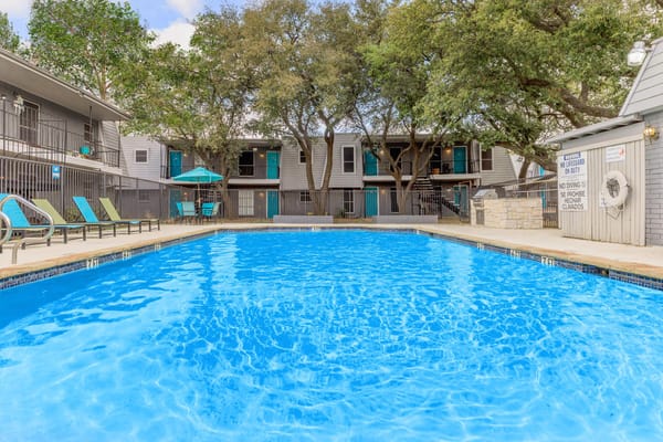 Swimming pool with lounge chairs surrounded by greenery