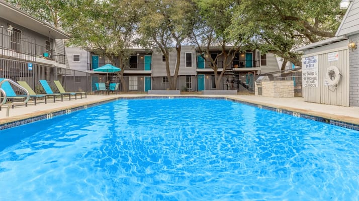 Swimming pool surrounded by trees and buildings