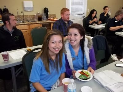 Staff members smiling at a table with food