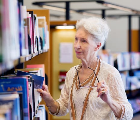 Senior resident browsing books in a library