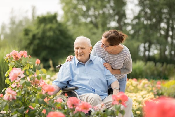 Resident smiling in a garden with flowers