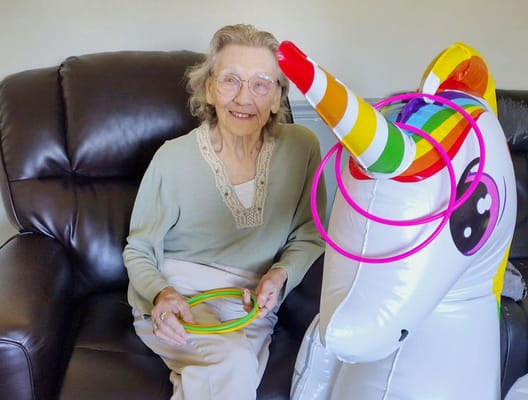 Resident enjoying time with a colorful inflatable unicorn