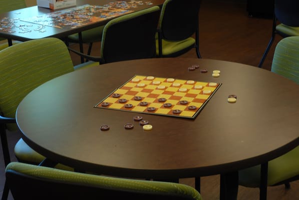Checkers game set up on a table with chairs around
