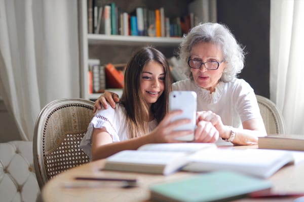 A senior woman and a girl looking at a smartphone together