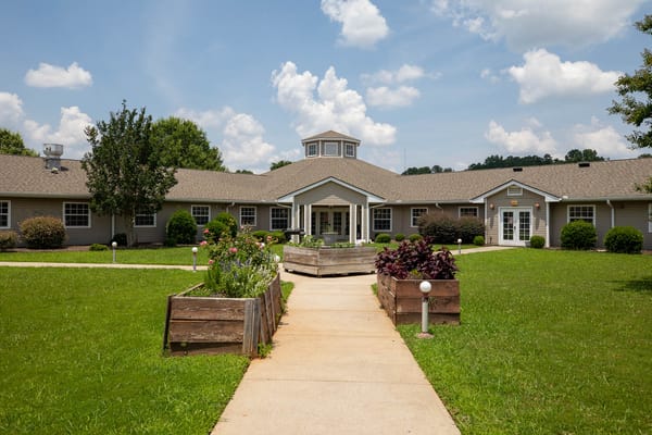 View of the facility's exterior with pathway and gardens