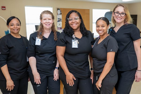 Five staff members posing in a bright interior