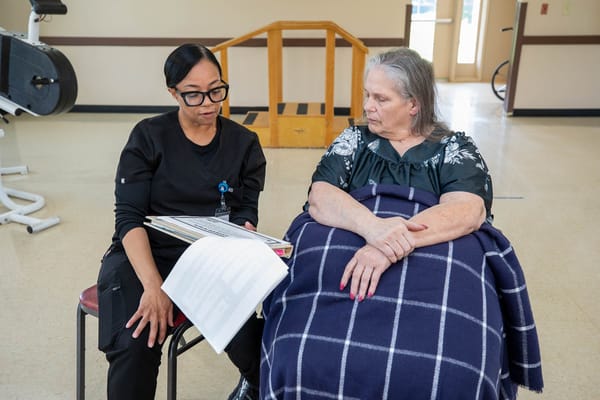Staff member discussing plans with a resident in an activity room