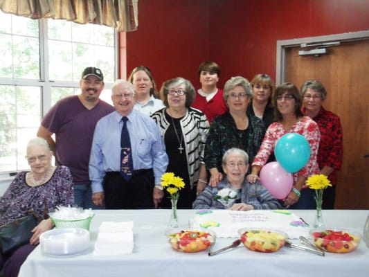 Residents celebrating a birthday with family and staff