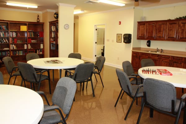 Interior view of a common activity room with tables and chairs