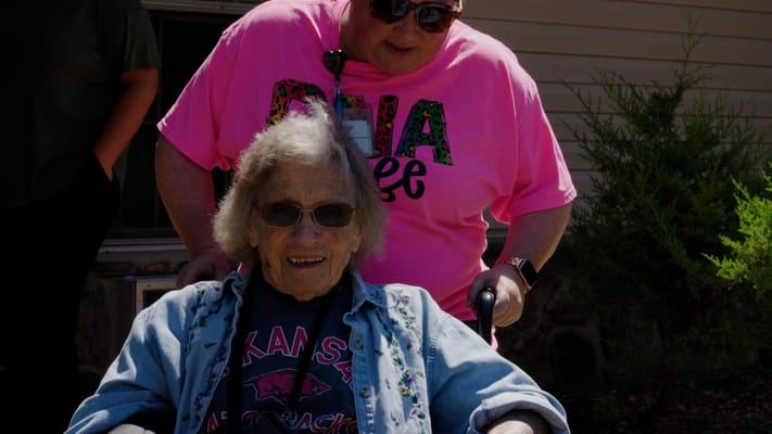 Resident smiling while being assisted outdoors