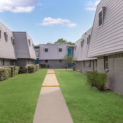 Pathway between buildings in a green outdoor area