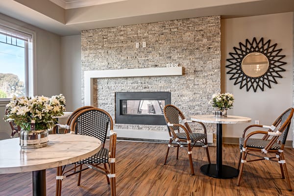 Cozy common area with tables and a fireplace