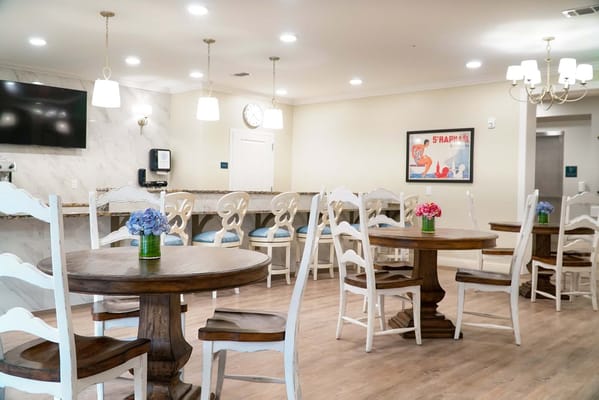 Bright common area with tables and floral decor