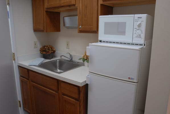 Interior kitchenette area with refrigerator and sink