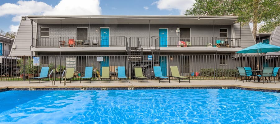 Outdoor pool area with lounge chairs and blue doors