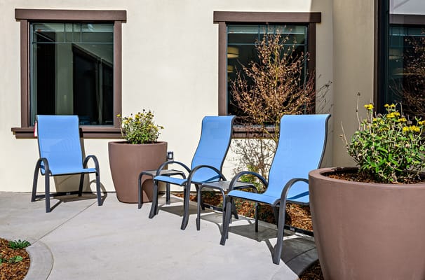 Outdoor seating area with blue chairs and flower pots