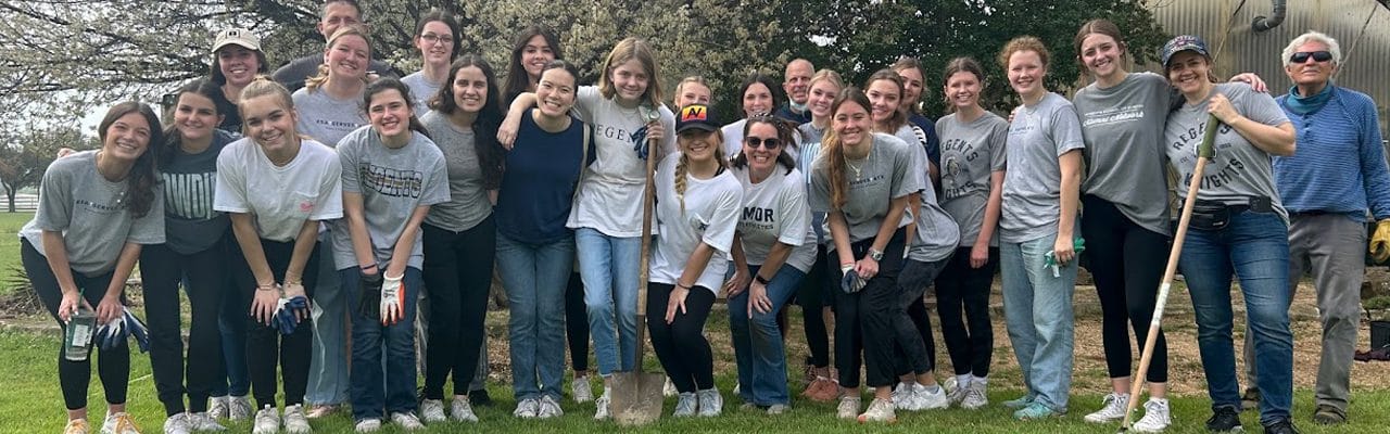 Group of volunteers posing outdoors in gray shirts