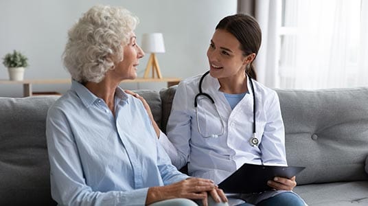A caregiver talking with a resident in a cozy setting