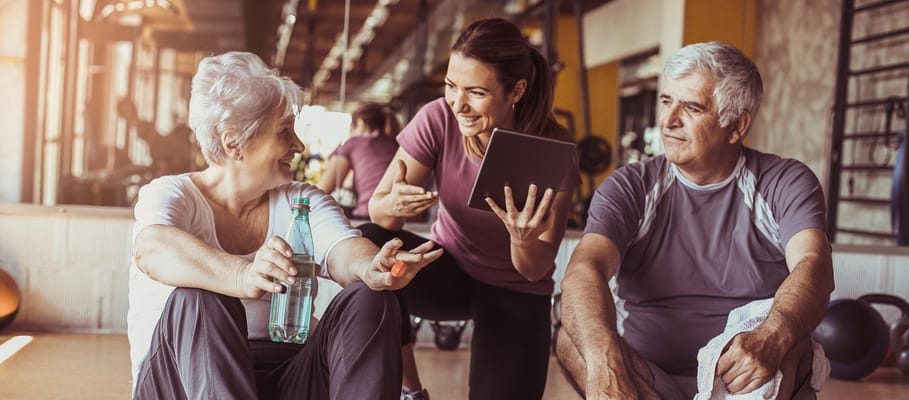 Residents and staff interacting in a gym setting