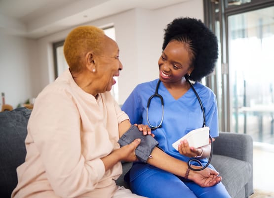 A caregiver and resident smiling during a health check