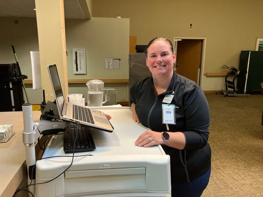 Staff member at reception desk smiling