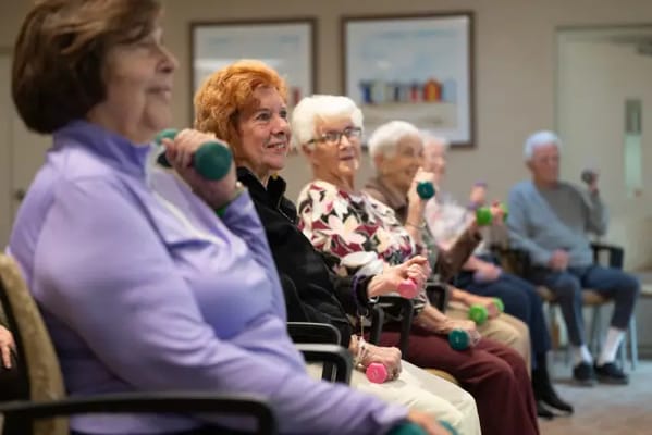 Residents participating in a group exercise class with weights