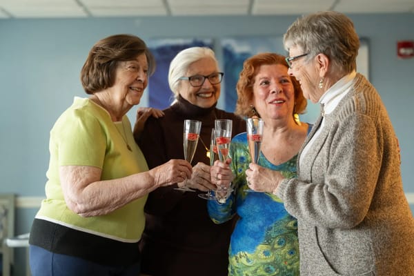 Residents celebrate with glasses in a common area