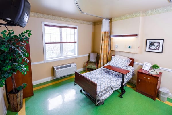 A cozy resident room with a hospital bed and furnishings