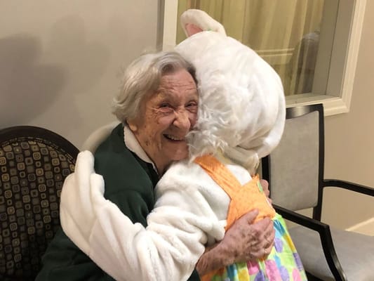 Elderly resident hugging a costumed character