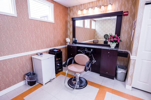 Hair salon area with styling chair and mirror
