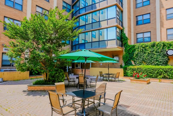 Outdoor seating area with green umbrellas and plants