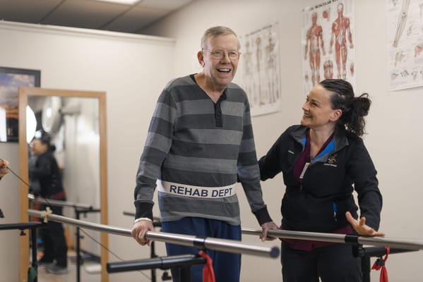 Resident participating in therapy with staff assistance