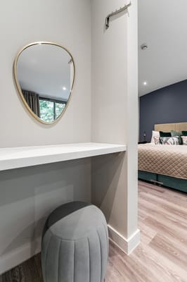 A modern private resident room with a mirror and stool